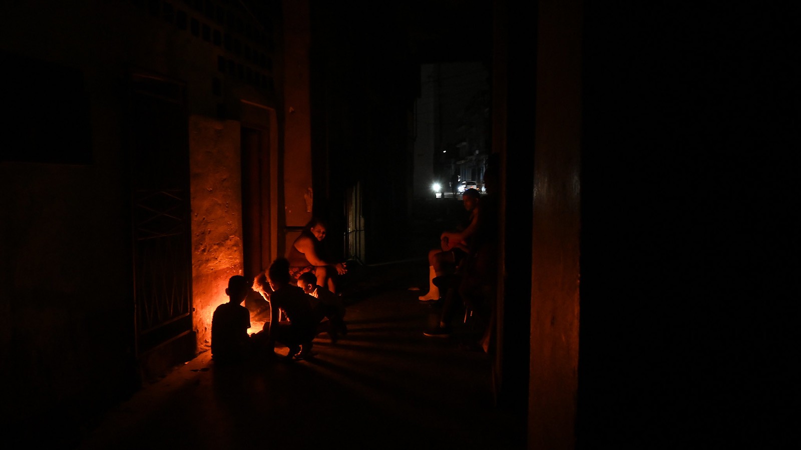 Havannalaisperhe istuu talonsa edustalla taskulamppujen loisteessa sähkökatkon aikana. Kuubalaiset pelkäävät, että Yhdysvaltojen toimet pahentavat entisestään jo ennestään suurta sähkövajetta.